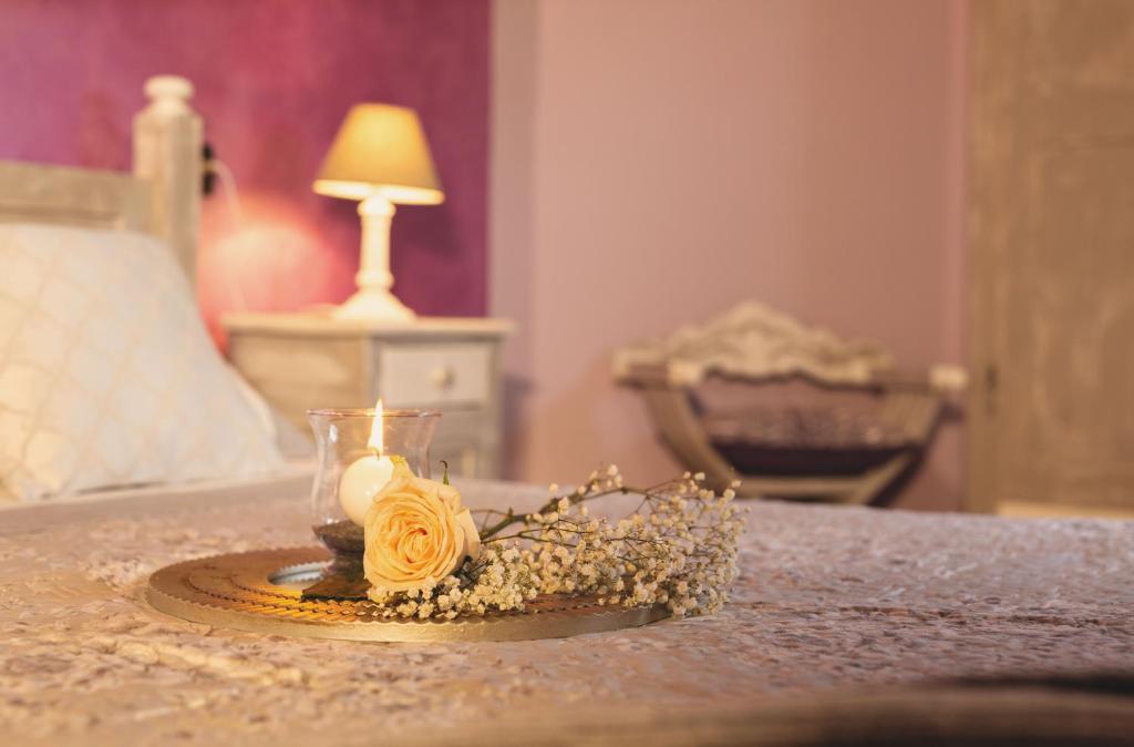 Casa di campagna في سبوليتو: وجود شمعة وزهور على طاولة في غرفة النوم