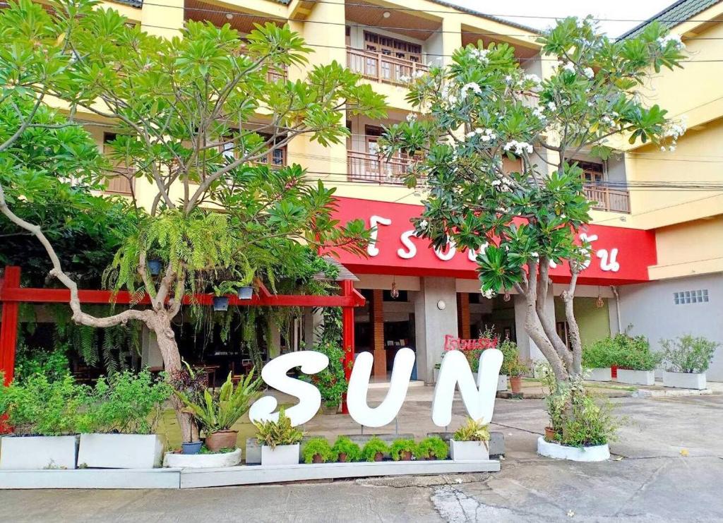 a sun hotel with trees in front of it at Sun Hotel in Phetchaburi