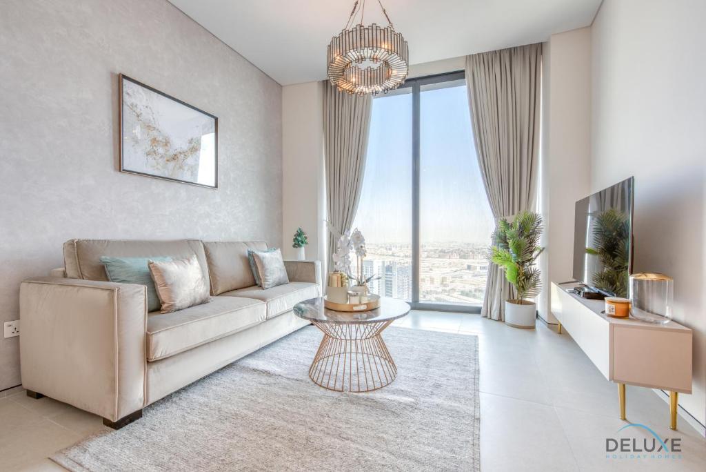 a living room with a couch and a large window at Serene 1BR at The Address Residences in JBR by Deluxe Holiday Homes in Dubai