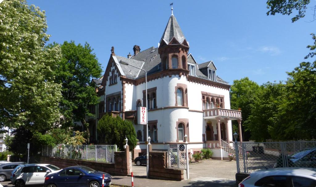 duży biały dom z wieżą na górze w obiekcie Hotel am Berg w Frankfurcie nad Menem