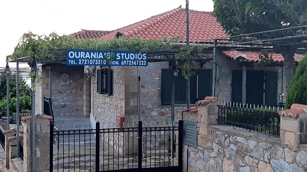 a building with a fence and a sign on it at Ouranias Studios in Kardamyli