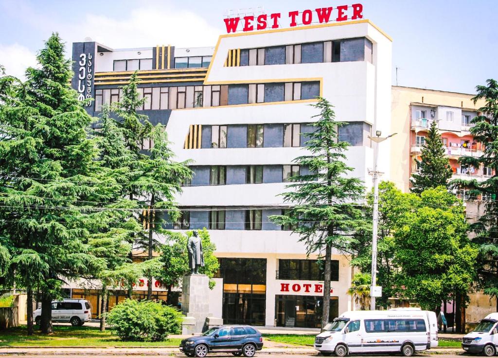 un hotel con coches aparcados delante en West Tower Hotel en Kutaisi