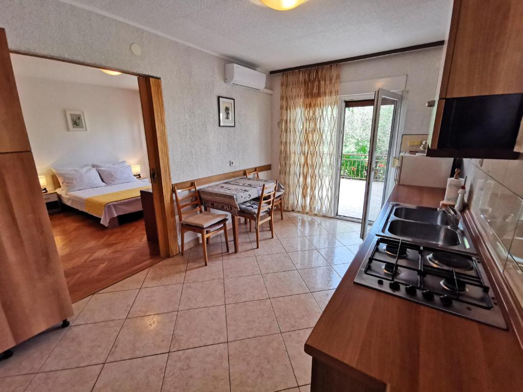 a room with a kitchen and a bedroom with a bed at EDITA 2 pax in Crikvenica