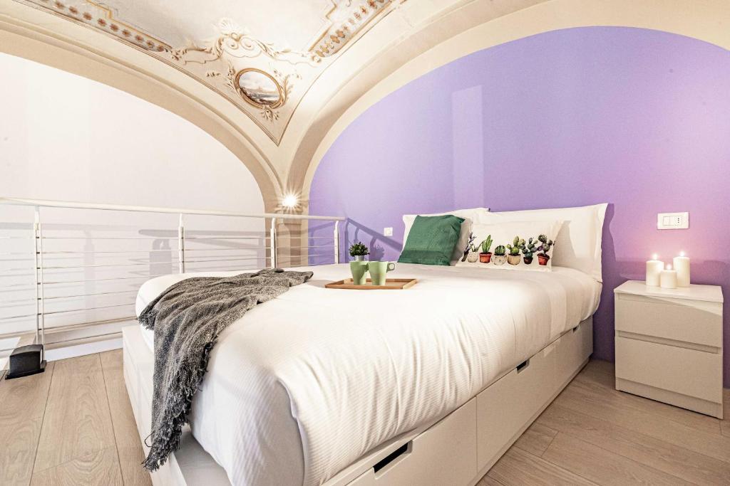 sypialnia z fioletowymi ścianami i dużym łóżkiem w obiekcie Realkasa Luxury S.Orsola Apartments w Bolonii