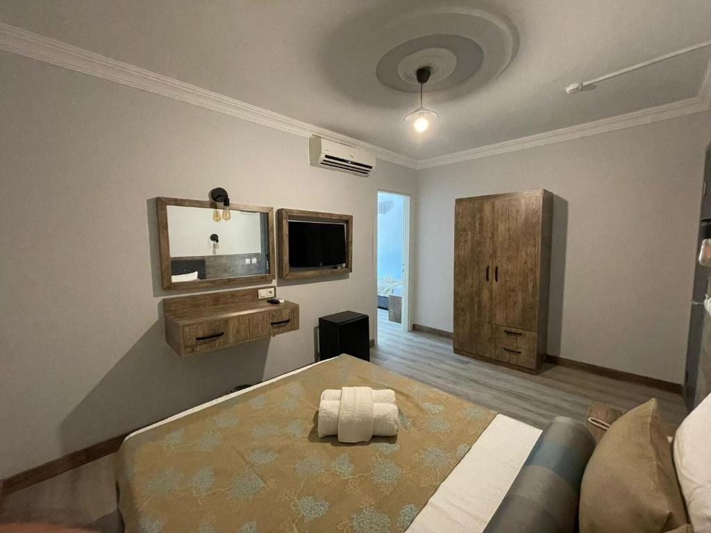 Habitación con cama, TV y sofá. en Seven City Hotel en Antalya