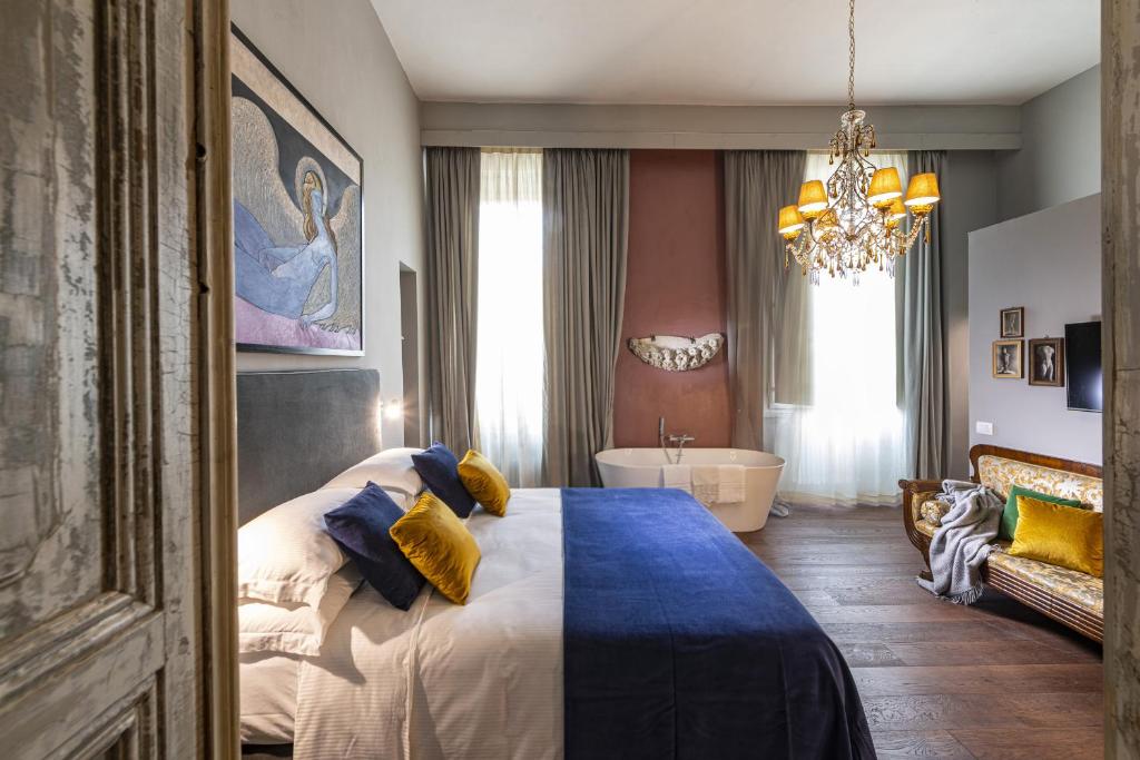 a bedroom with a bed and a tub and a chandelier at Casa Botticelli in Florence