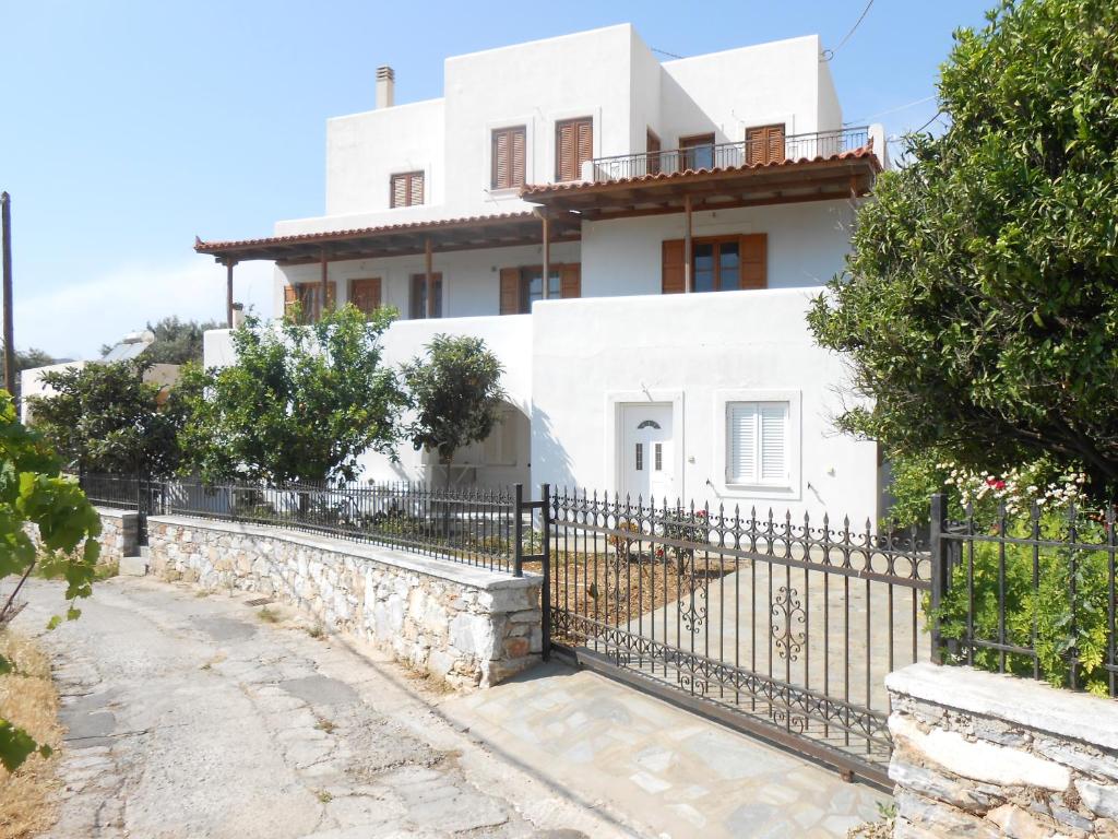 a white house with a black fence at Chrysolithos Kerami Apartments in Khalkíon