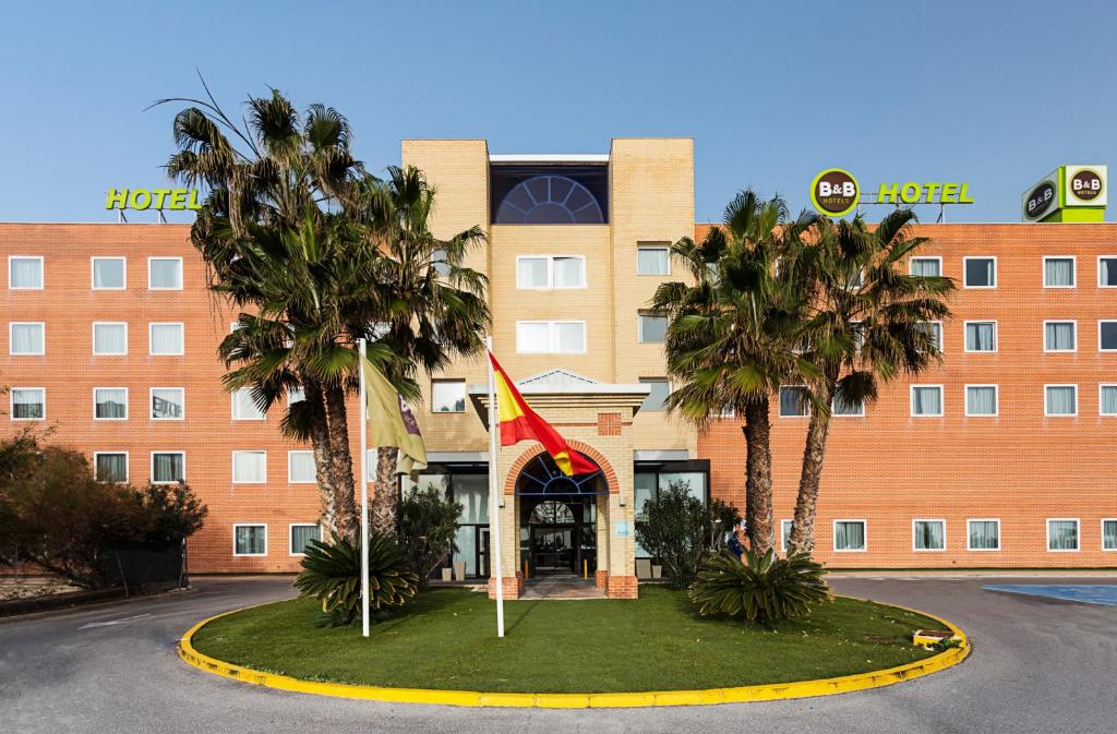ein Hotel mit Palmen vor einem Gebäude in der Unterkunft B&B HOTEL Alicante in Alicante