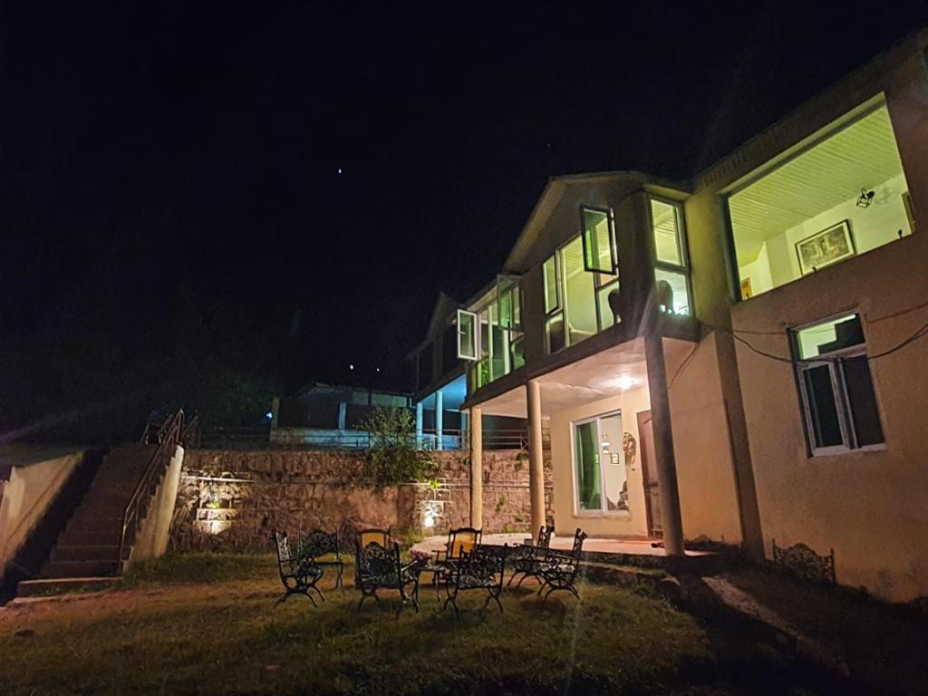 a group of chairs in front of a house at night at The Generals Inn in Bhurban