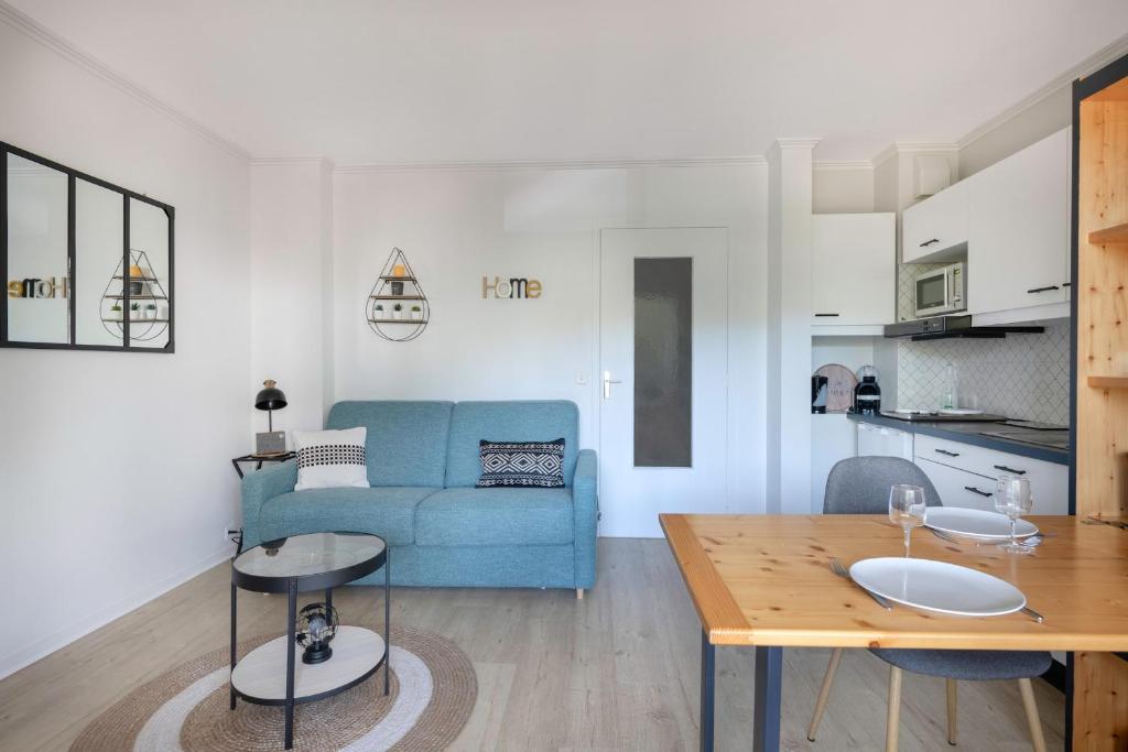 un salon avec un canapé bleu et une table dans l'établissement Appartement pour 4 avec balcon - centre-ville, à La Baule