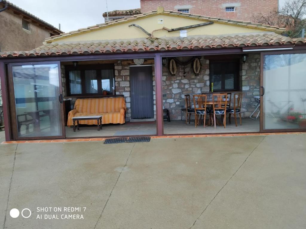 a patio with glass doors and a table and chairs at Los Aladros in La Puebla de Valverde