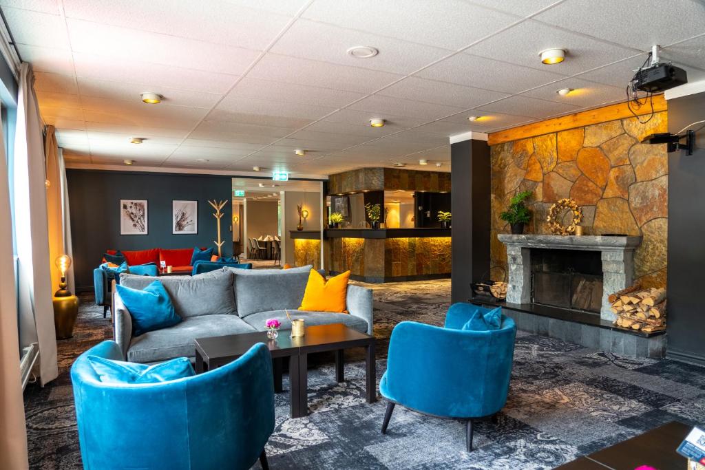 a lobby with a couch and chairs and a fireplace at Thon PartnerHotel Otta in Otta