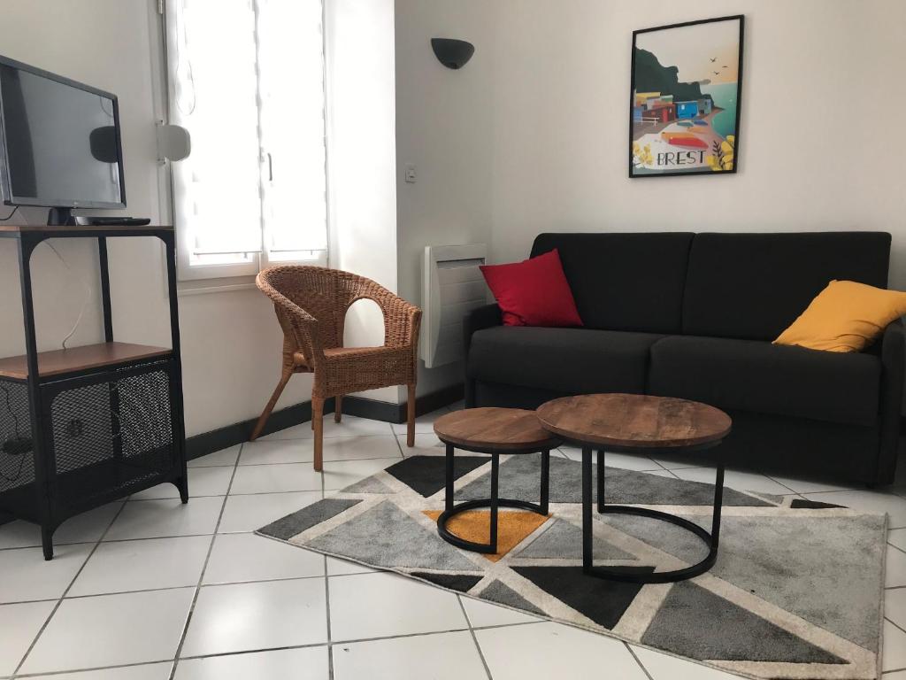 uma sala de estar com um sofá e uma mesa em Urban Chic 44 m2 em Brest