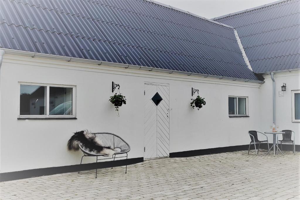 a white building with a horse sitting on a chair at Ferielejlighed i smukke omgivelser in Ørsted