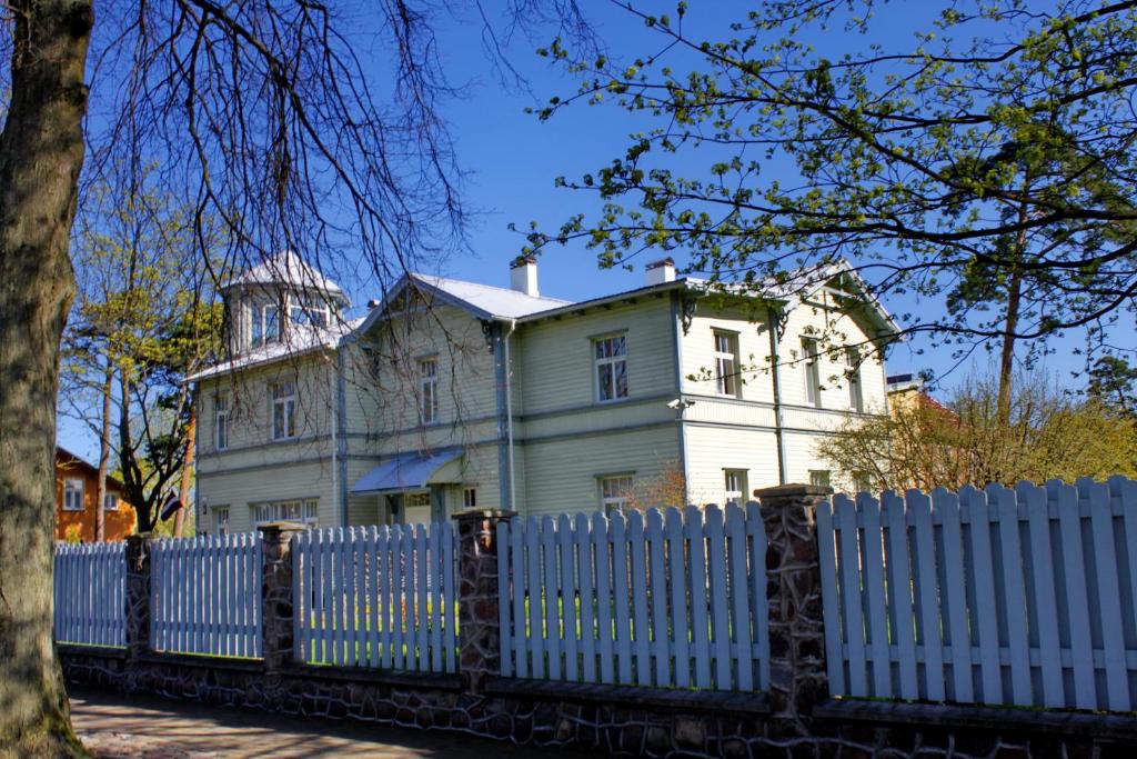 an old white house behind a white fence at Villa Ostmala in Ventspils