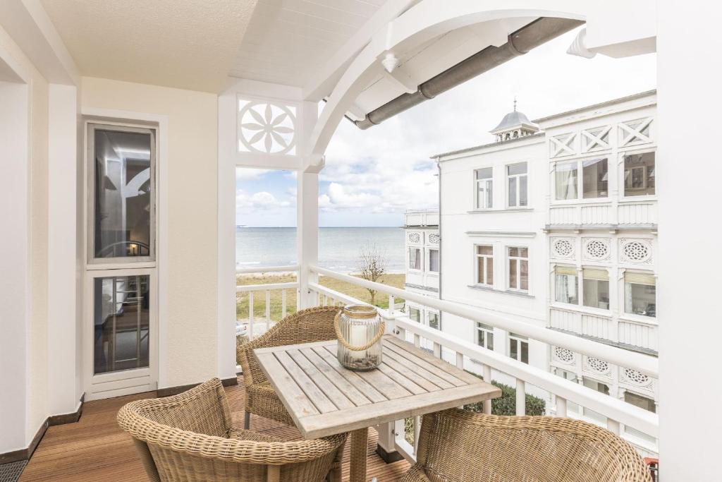 a balcony with a table and chairs and the ocean at Villa Strandperle Nr. 17 in Binz