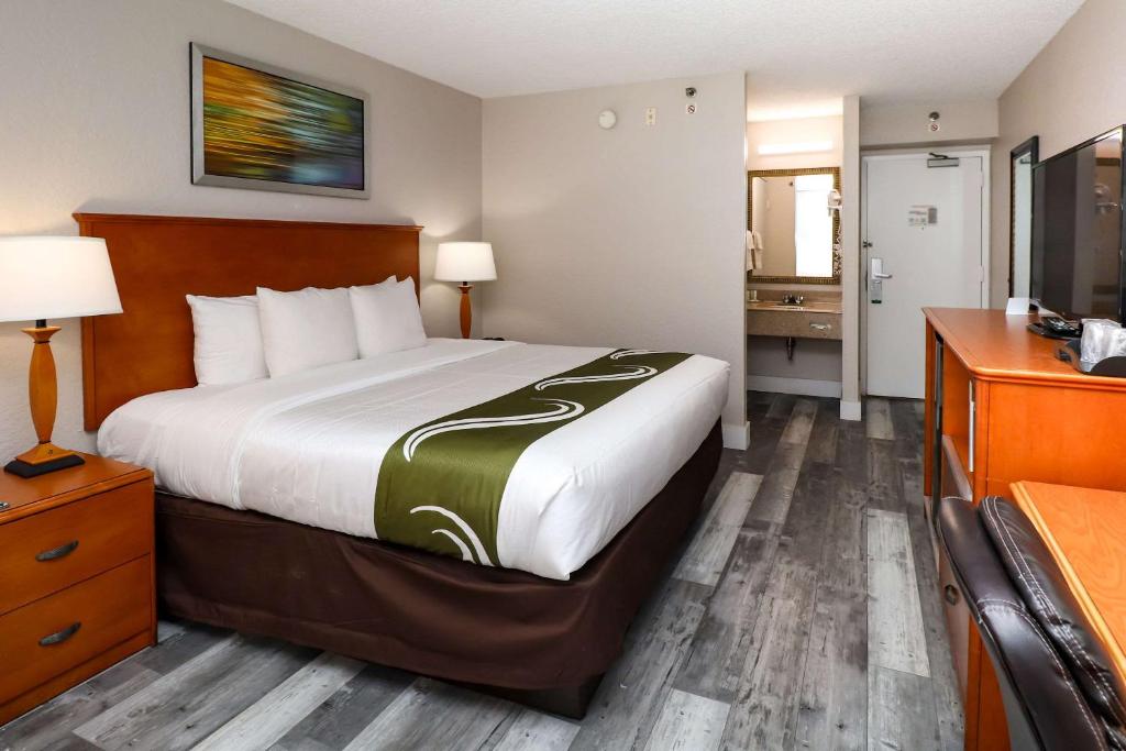 a hotel room with a bed and a desk at Quality Inn Miami Airport - Doral in Miami