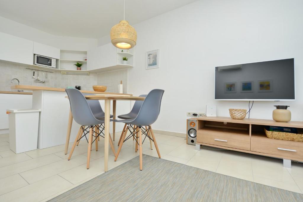 a kitchen with a table and two chairs and a tv at Apartman Ema Dobropoljana in Dobropoljana