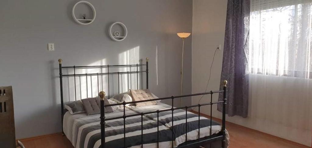 a bedroom with a metal bed in a room with a window at Appartement in Tiszagyenda