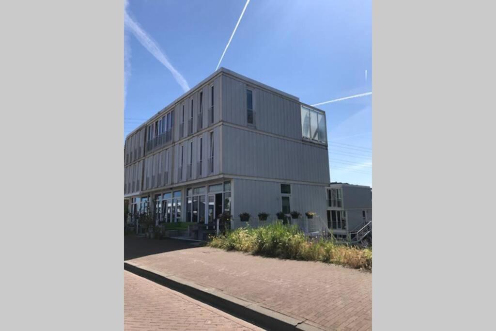 a large gray building with windows on a street at Large and cosy house on the water: free Parking in Amsterdam