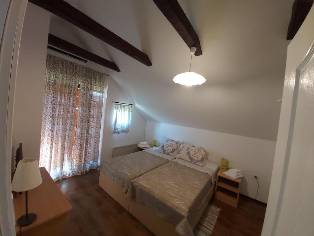 a small bedroom with a bed and a window at Izletište Opatovac in Opatovac