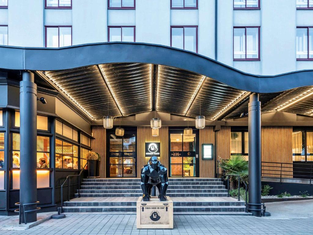 una estatua sentada frente a un edificio en Mercure La Roche Sur Yon, en La Roche-sur-Yon