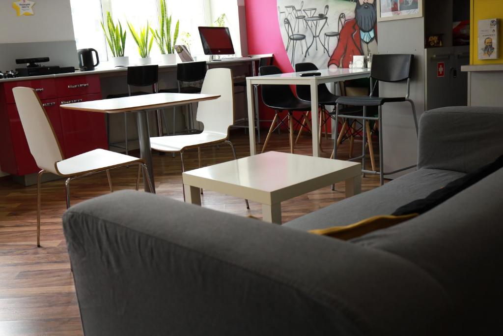 a living room with a couch and tables and chairs at HD Hostel Izhevsk in Izhevsk