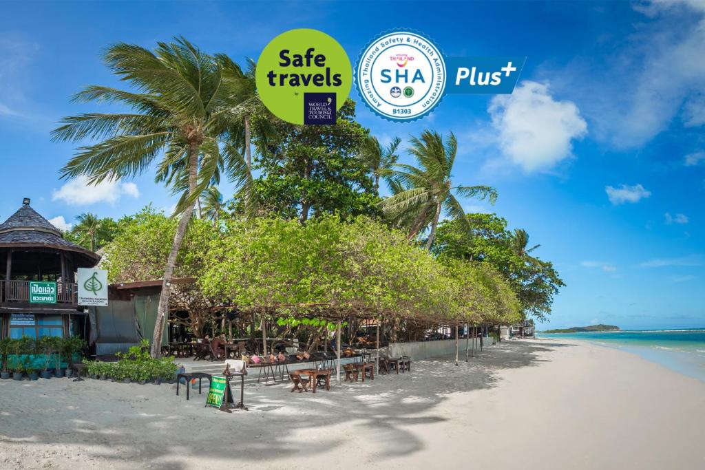 een strand met tafels en stoelen en een bord met veilig reisverkeer bij Chaweng Garden Beach Resort - SHA Plus in Chaweng Beach