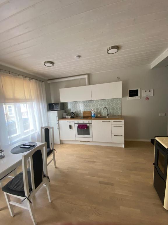 a kitchen with white cabinets and a table at Tamula apartament in Võru