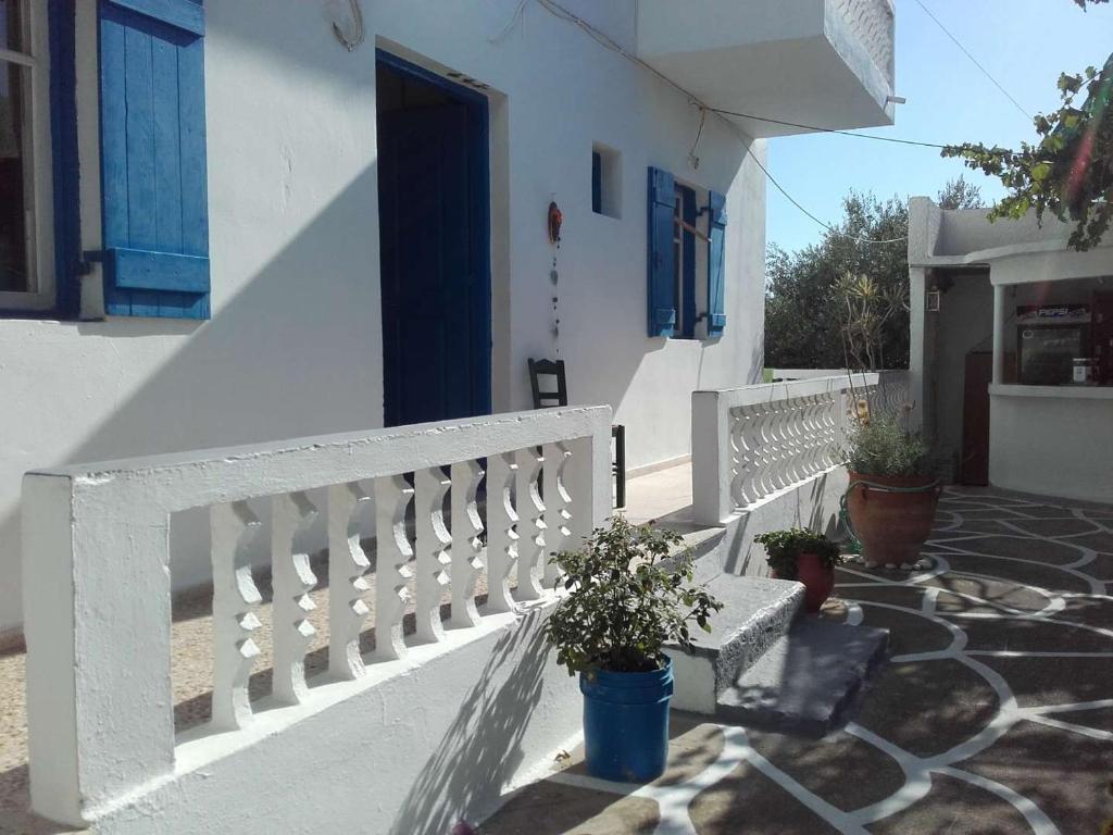 uma casa branca com um banco e uma porta azul em Nikos Taverna and Apartments em Lefkos Karpathou