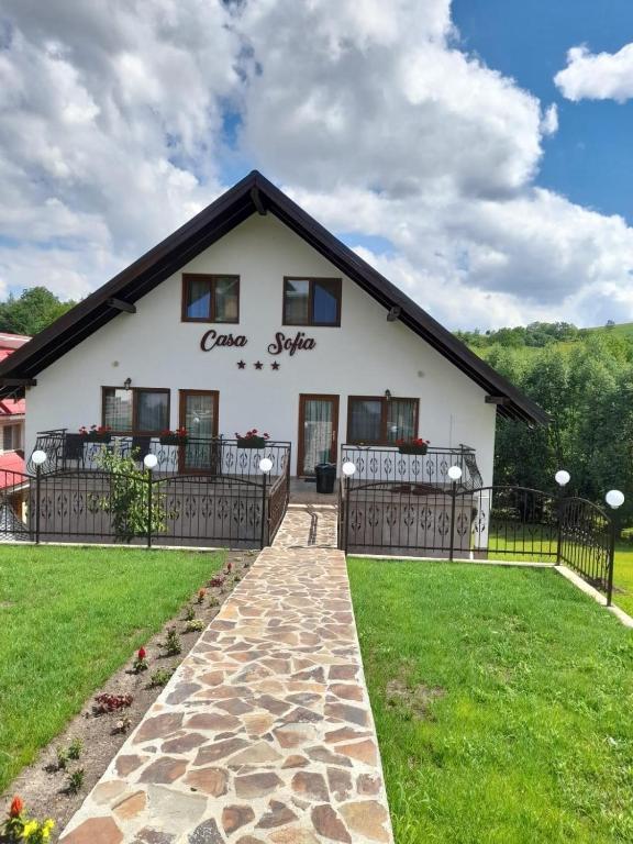 a white house with a black roof at Casa Sofia in Bălţăteşti