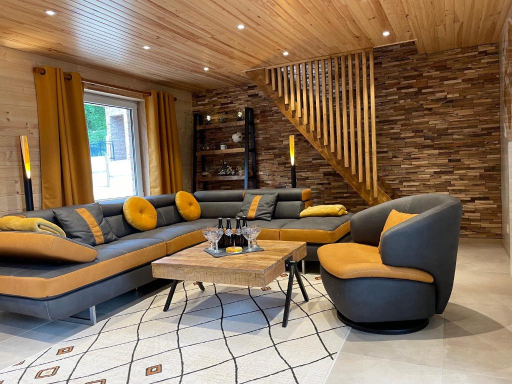 ein Wohnzimmer mit Sofas und einem Tisch in der Unterkunft La Petite Maison au bord de l'eau in Hastière-par-delà