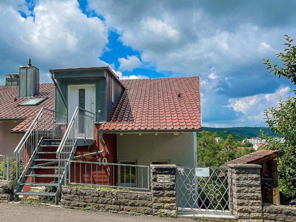 ein Haus mit einem roten Dach und einer Treppe in der Unterkunft Ferienwohnung im Eisenbergweg in Bad Mergentheim