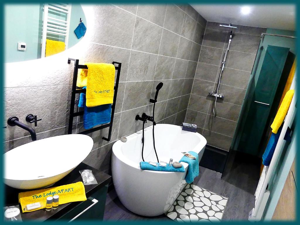 uma casa de banho com uma banheira, um lavatório e um chuveiro em The Lodge A'PART em Néewiller-près-Lauterbourg
