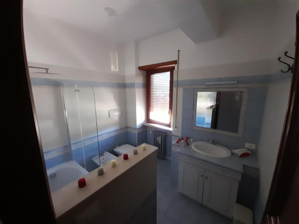 łazienka z 2 umywalkami, wanną i lustrem w obiekcie DreamHouse w mieście LʼAquila