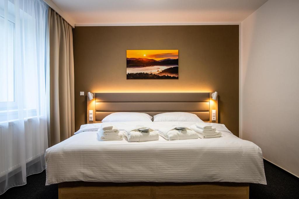 1 dormitorio con 1 cama con 2 toallas en Penzion Čertovy skály, en Lidečko
