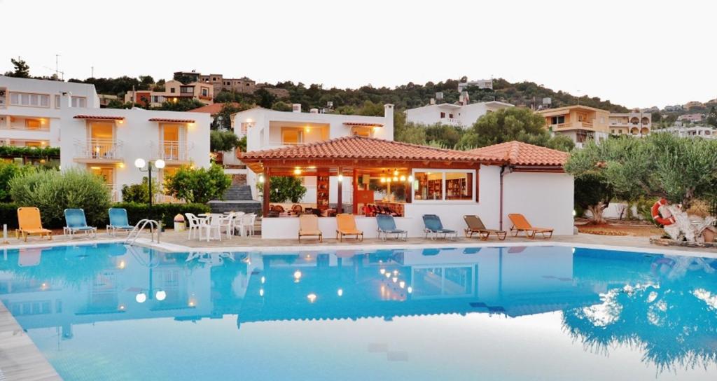 a villa with a swimming pool in front of a house at Primavera Paradise Apartments in Agios Nikolaos