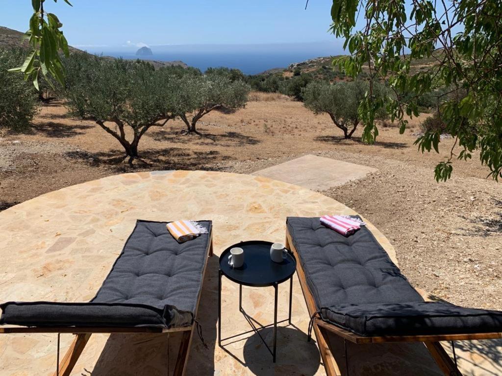 two chairs and a table with a view of the ocean at Kalamavros nature home - Kythoikies holiday houses in Kythira