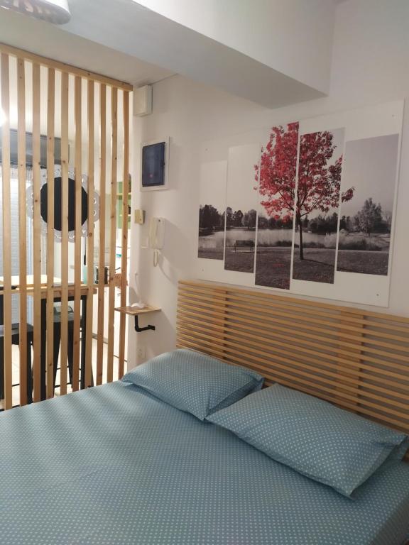 um quarto com uma cama e algumas fotografias na parede em Blue Lagoon Studio em Mesolongion