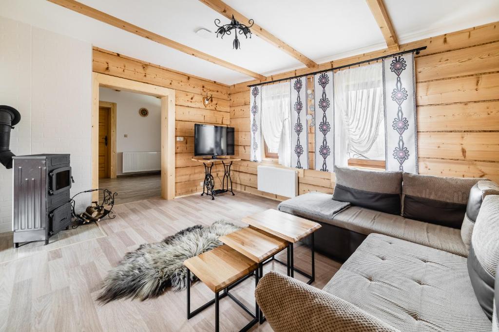 a living room with a couch and a tv at Domek u Stochów in Biały Dunajec