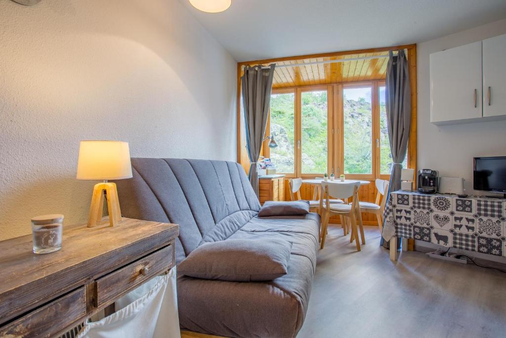 salon z kanapą i stołem w obiekcie L'Eclose - Alpe d'Huez w mieście LʼHuez