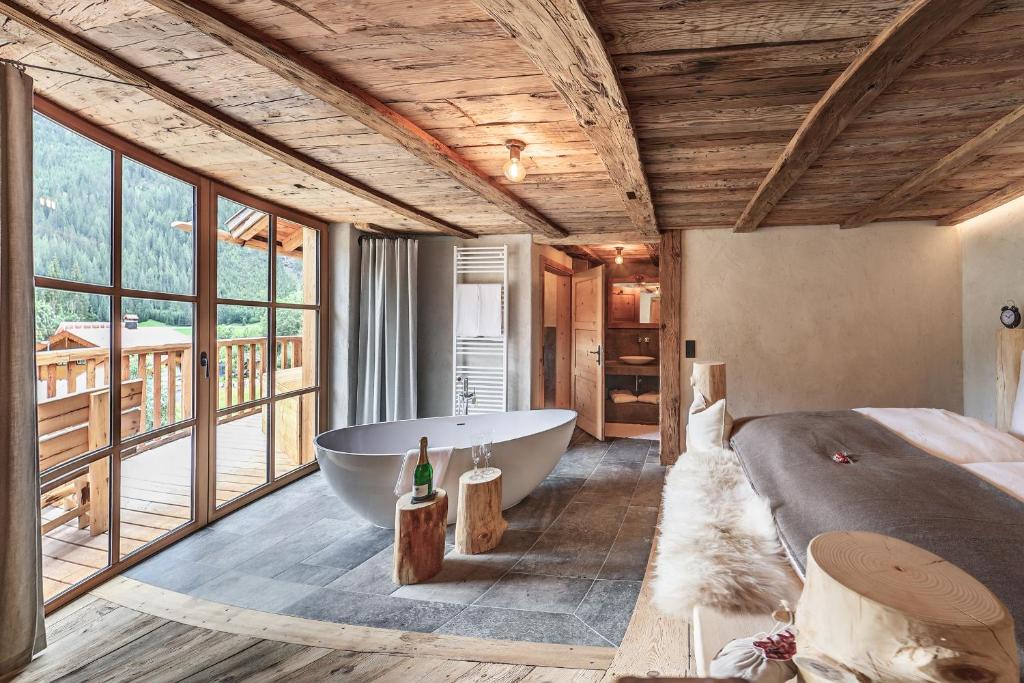 a bedroom with a tub and a bed and a bed and a bed at Lass Zeit am Lech in Bach