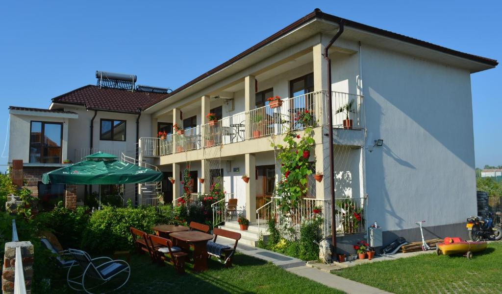 an apartment building with a patio and a table and umbrella at Vila Azaleea in Vama Veche