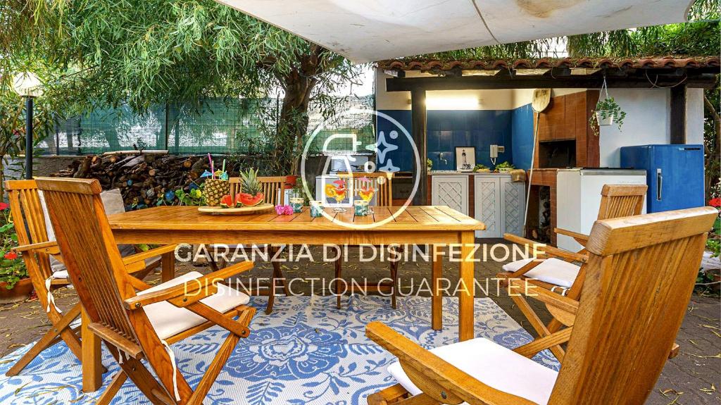 Une table et des chaises en bois sont disponibles sur la terrasse. dans l'établissement San Leonardo with private beach, à Villaggio San Leonardo