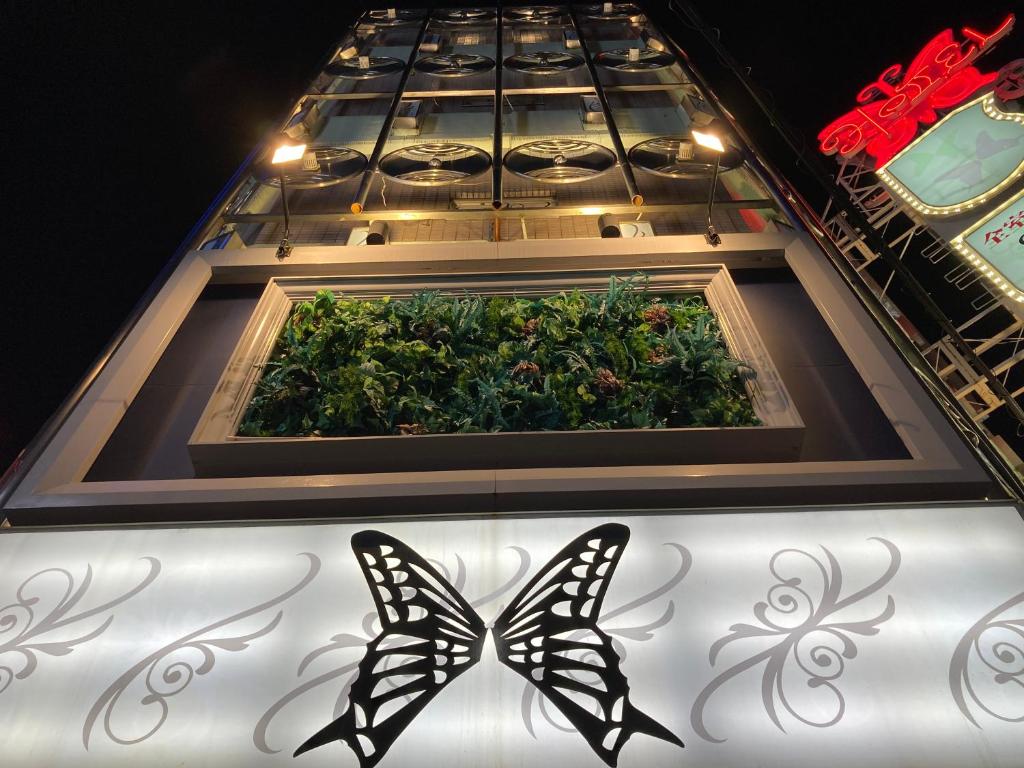 two butterflies are standing in front of a garden at ホテル チョウ 十三 in Osaka