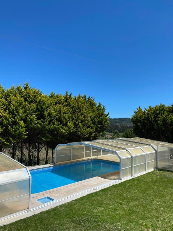 a house with a swimming pool with a greenhouse at Quinta Manuel Santo in Nazaré