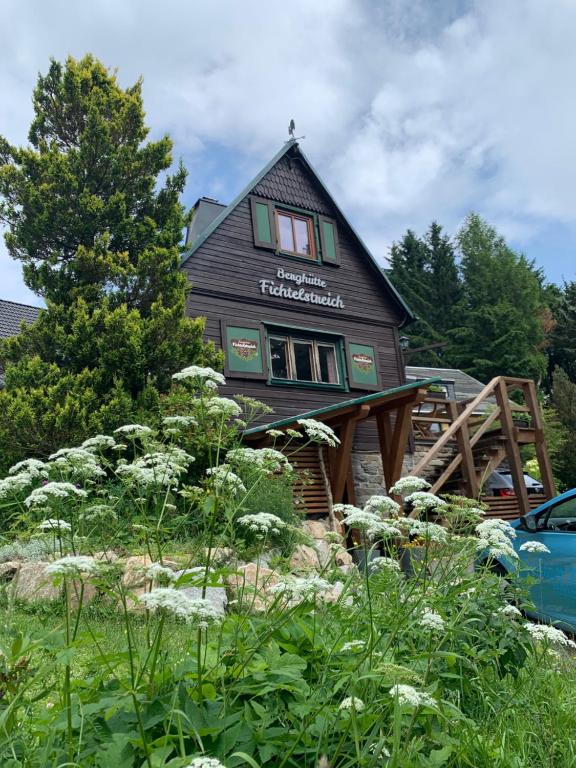 ein Haus auf einer Holzterrasse in der Unterkunft Berghütte Fichtelstreich in Kurort Oberwiesenthal