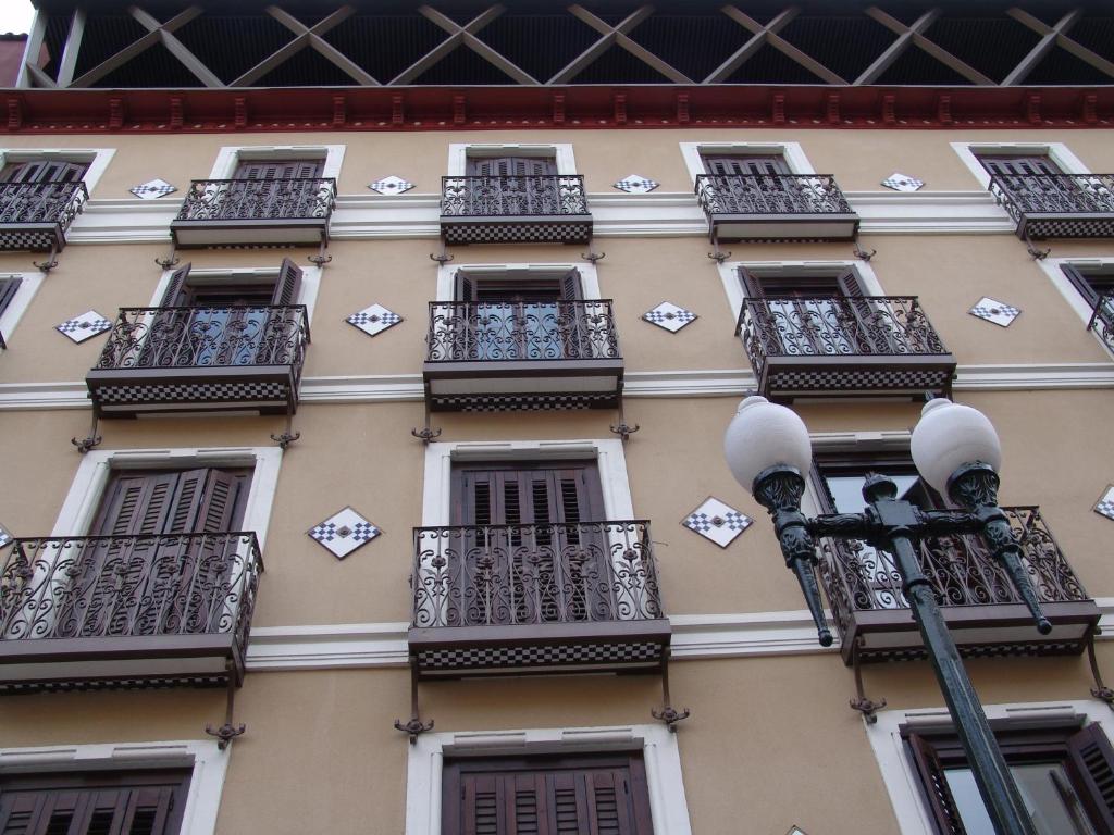 un edificio con balcones y luz de la calle en Apartamentos Zaragoza Coso, en Zaragoza