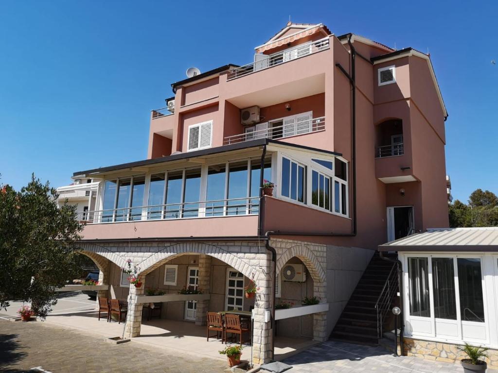 a large pink building with a balcony on top at Marija in Šibenik