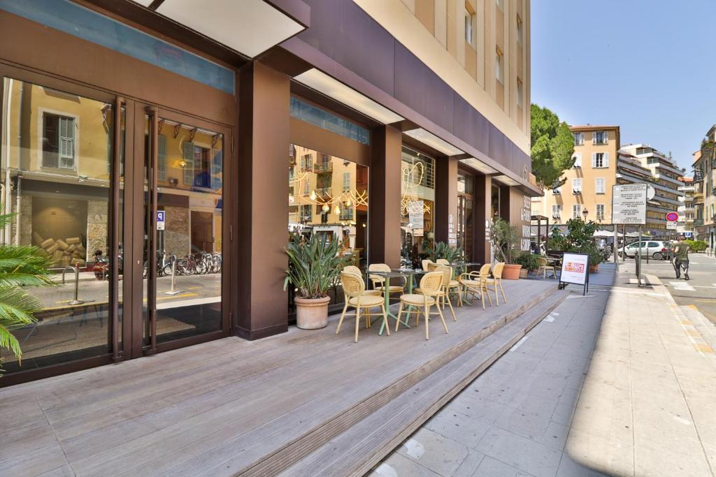 a store front with tables and chairs on a sidewalk at Hotel du Pin Nice Port by Soniho in Nice